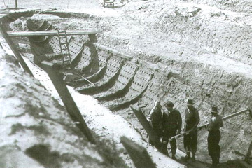 Archaeologists standing inside the buried Sutton Hoo longship. The ribs and nails that you see are nothing more than discoloured sand.