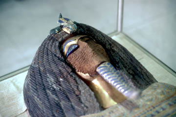 The decayed wood still retains a vague impression of the golden features ripped from the face of the coffin from KV55