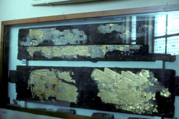 The recovered fragments of gold leaf from KV55 and the fragile wood on which they were mounted in the Cairo Museum.