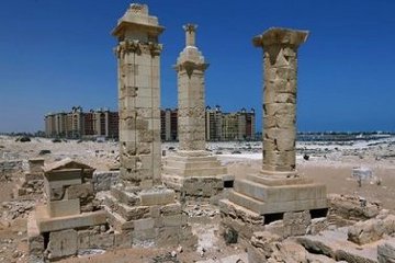 Three of the unique pillar-tombs of Leukaspis with buildings of the modern resort in the background.