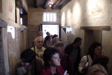 A throng of tourists crowds into Pompeii's famous - and tiny - brothel. It is hard to know whether they are thrilled or disappointed by the infamous frescoes.