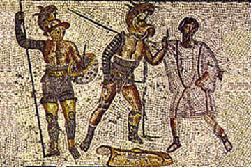 A referee stands in the background while two gladiators fight. A referee stands in the background while two gladiators fight.